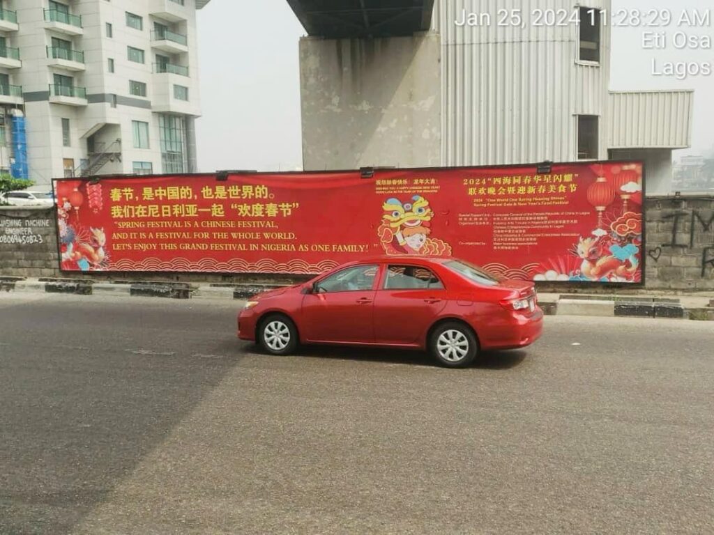 Wall mounted billboard and a red Toyota car.