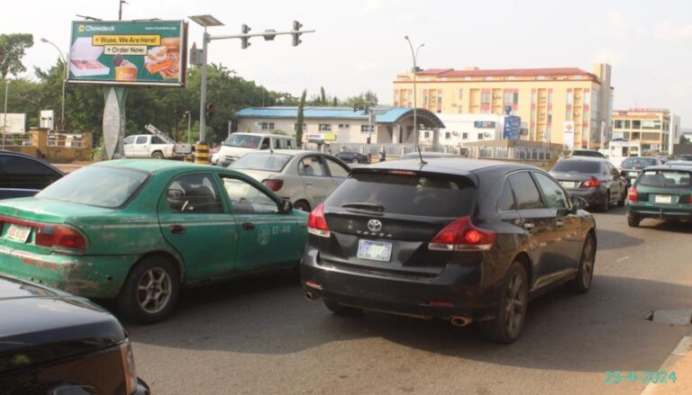A glance of chowdeck billboard campaign with car traffic in Wuse, Abuja